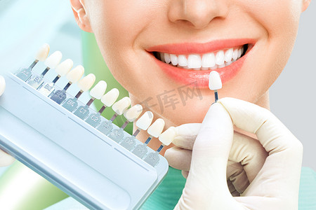 check摄影照片_Close up portrait of Young women in dentist chair, Check and select the color of the teeth. Dentist makes the process of treatment in dental clinic office. Teeth whitenning