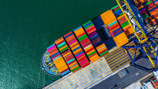 集装箱码头有工作起重机桥卸货的集装箱货运船舶, 深海港口空中视图集装箱船.