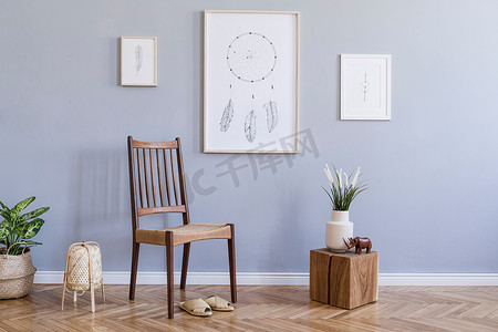 现代波希米亚室内设计的客厅与复古椅子，藤灯，木立方体，植物，鲜花，模拟海报框架和优雅的配件。时尚的家居装饰。模板。灰色墙壁