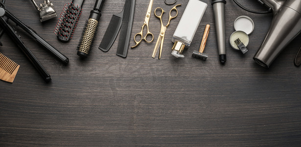 木制背景的经典造型和理发工具。放在深色木制桌子上的理发店乐器的顶视图.