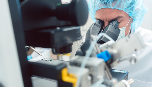 医生或科学家在实验室里看显微镜