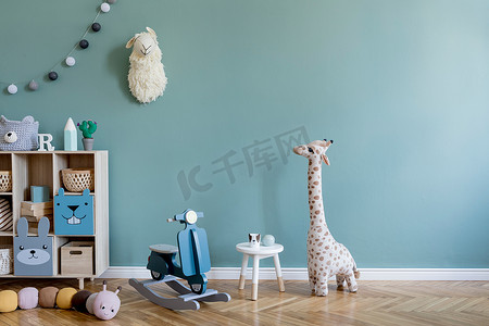 斯堪的纳维亚室内设计有木制橱柜、桌子、许多毛绒玩具和木制玩具。 时尚可爱的儿童房装饰。 桉树背景墙。 复制空间。 模板.