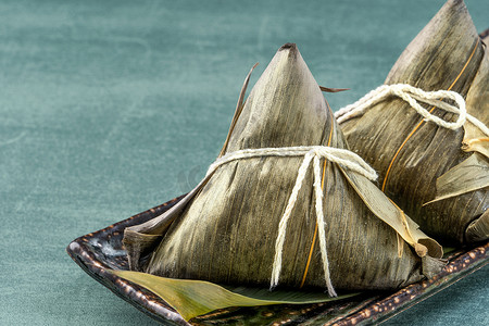 竹叶龙舟摄影照片_特写，复制空间，著名的亚洲美味食品在龙舟（段武）节，蒸饺子金字塔形包裹的竹叶由粘米原料