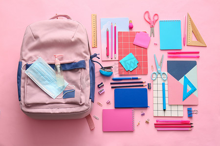彩色背景的学校背包和文具