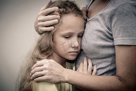 一个悲伤的女儿抱着他的母亲的画像
