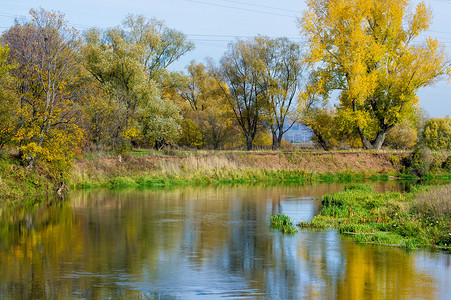 秋冬天摄影照片_秋天的风景。河, 秋树的颜色不同。旧的干草。令人惊讶的美丽风景。哀伤的时间, 在冬天寒冷的前夕