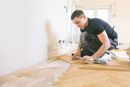 男子在家居改善过程中安装橡木地板   