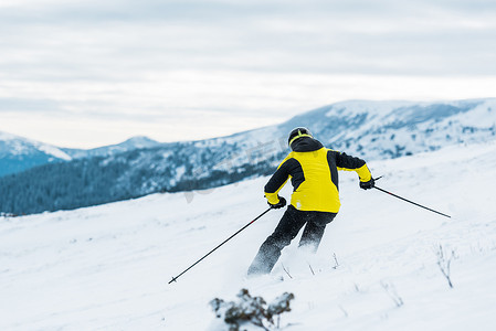 持钢盔的滑雪者的背景图和冬季滑雪者在斜坡上的滑行 