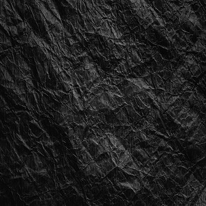 皱褶的黑色牛皮纸。皱褶的黑色再生纸的纹理。纸张和垃圾的回收和再利用的概念.