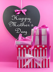 堆栈的美丽粉色条纹和圆点礼品与心形状黑板与幸福的母亲一天消息.