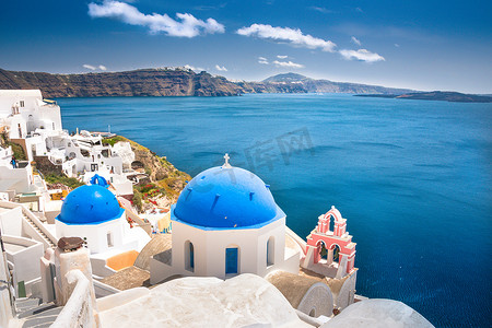 蓝色摄影照片_希腊圣托里尼岛上的奥亚镇。卡尔德拉、爱琴海上空有蓝色圆顶的传统而著名的房屋和教堂
