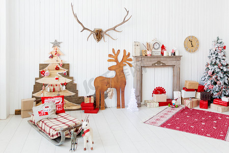 圣诞节和新年家庭室内-木鹿、 蜡烛、 夏娃树与礼物的壁炉架上的详细信息.