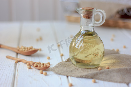 玻璃瓶里放着豆油，周围夹着大豆.