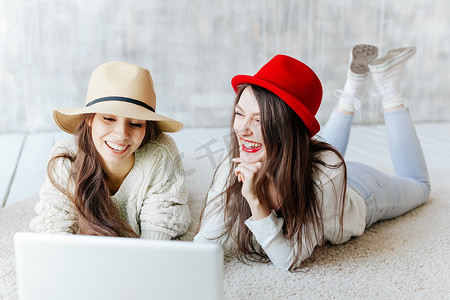 Best friends with laptop together sitting at cafes terrace