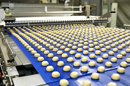 Controlling the work of huge conveyor machine producing spice cakes at the confectionary plant. Cookie production line. Innovative biscuit production..