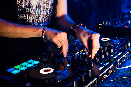 搅拌机和 dj 摊位在夜总会与 dj 混合音乐和控制调节器的手
