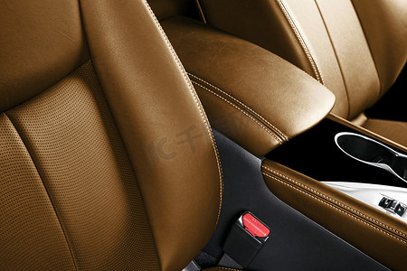 豪华轿车棕色皮革内饰.皮革汽车座位的部分细节与缝制。舒适的穿孔橙色皮革座椅。棕色穿孔皮革。车里面