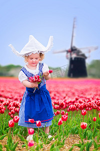 在郁金香领域与风车荷兰民族服装的小女孩