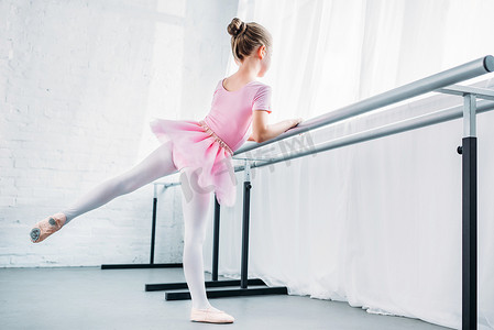 可爱的小芭蕾舞演员在粉红色的芭蕾舞短裙在芭蕾工作室练习 