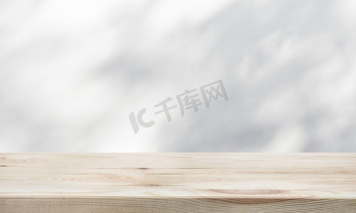 墙面上有树叶阴影的白色木桌.用于产品展示和自然概念