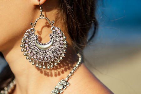 女性模特耳环和项链在天堂热带海滩度假海边。印度妇女与昆丹珠宝传统印度服装sari.时尚银耳环在民族风格