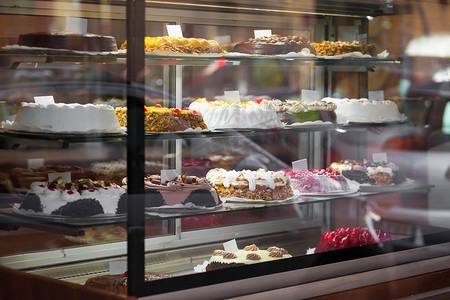 在糕点店的橱窗里吃糕点. 烘焙店货架上的甜食