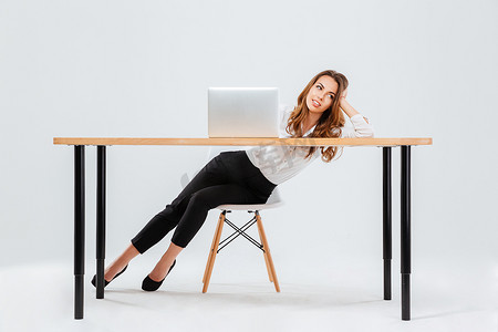 Woman resting while sitting at the office desk with laptop