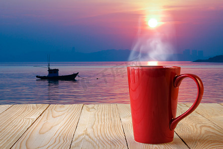 与太阳崛起背景上烟红色咖啡杯