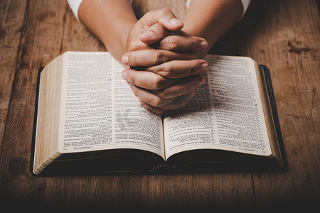 person摄影照片_Close up of christian woman hand on holy bible are pray and worship for thank god in church with black background, adult female person are reading book, concept for faith, spirituality and religion