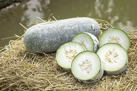 Winter melon is cut into pieces on the straw.