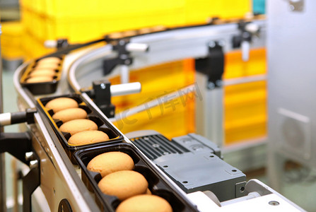work摄影照片_Controlling the work of huge conveyor machine producing spice cakes at the confectionary plant. Cookie production line. Innovative biscuit production..