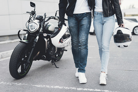 一个年轻的男孩和一个女孩站在附近的电动摩托车.