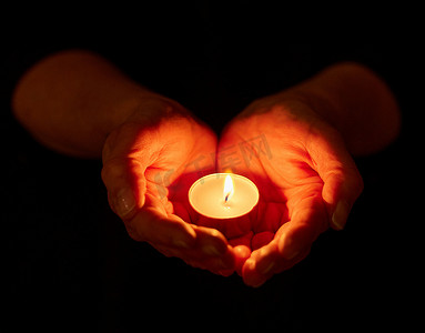 candle摄影照片_We have always held to the hope. a unrecognizable person holding a candle in the dark
