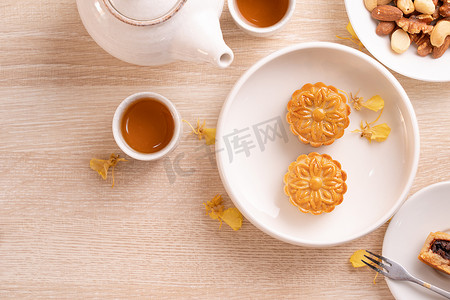 中秋节美味的月饼，图案优美，以黄花和茶装饰。节日午后糕点设计理念