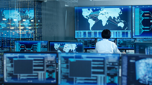 在系统控制室操作员坐在他的工作站多显示显示图形和物流信息.