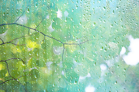 夏季雨湿玻璃/抽象背景景观在雨天窗外模糊背景