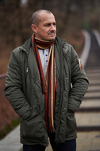winter摄影照片_Portrait of a mature man in dark green winter coat in the park