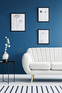花卉海报, 金属侧面表和白色沙发设置在一个蓝色的客厅内