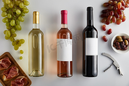 在葡萄酒、软木塞、橄榄和切碎的意大利面包上的白葡萄酒、玫瑰酒和红酒的顶部