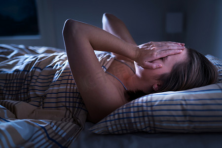 头痛摄影照片_失眠，睡眠呼吸暂停或压力的概念。半夜不眠的女人醒着，蒙着脸。女士无法入睡。梦魇或沮丧。头痛或偏头痛的痛苦.