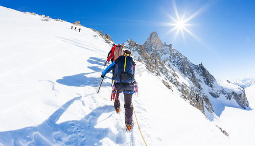 登山者攀登雪峰。在背景著名高峰 D