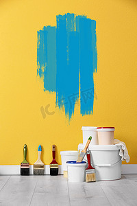 设置与装饰工具和油漆在黄墙附近的地板上
