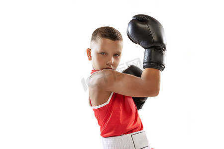 冠军。活力充沛的男孩、戴着运动手套的初学者和被白色背景隔离的红色制服拳击的肖像。运动,运动,学习,成就的概念.广告的复制空间