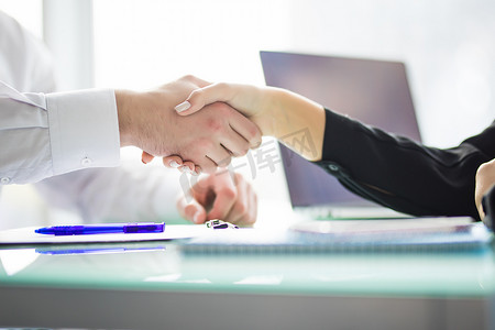 在会议中或在办公室谈判商务握手。因为签署合同或金融论文，伙伴感到满意。业务.