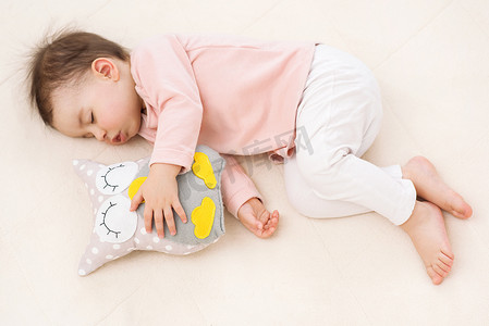 睡觉和做梦在床上的猫头鹰玩具漂亮宝贝女孩蹒跚学步