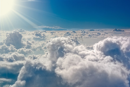 光辉摄影照片_暴风雨云与太阳光辉从上面。从飞机上查看.