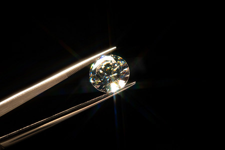 钻石摄影照片_在金属珠宝商的镊子中保留了钻石选择焦点，对抛光质量和污染进行了辉煌的石刻检查。天然碳材料，用于工业和时尚应用. 