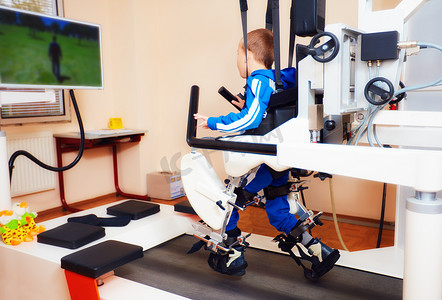 年轻的男孩通过机器人步态疗法在康复中心