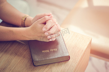 与圣经祷告坐在一起，双手交叉在圣经、精神和宗教祷告中。沟通，与上帝对话，爱与宽恕.