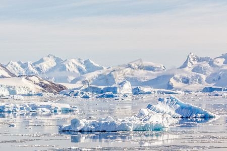 南极洲的背景是雪山和冰川, 在内科湾平静的水域上的冰山